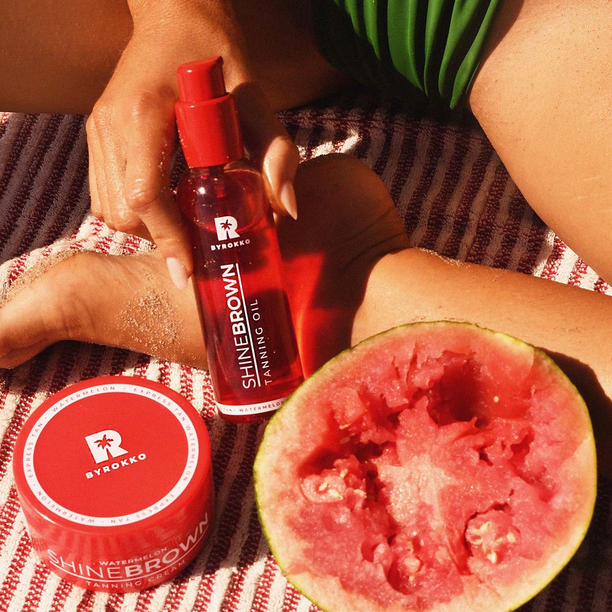 Watermelon Tanning Oil and Watermelon Tanning Cream beside a watermelon and a girl in a bikini.